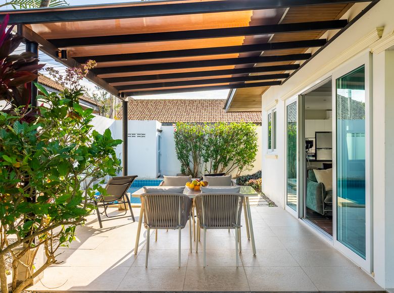 Covered patio dining table beside the garden