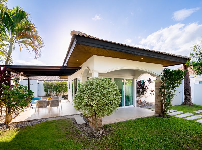The villa and its lawn under a blue sky