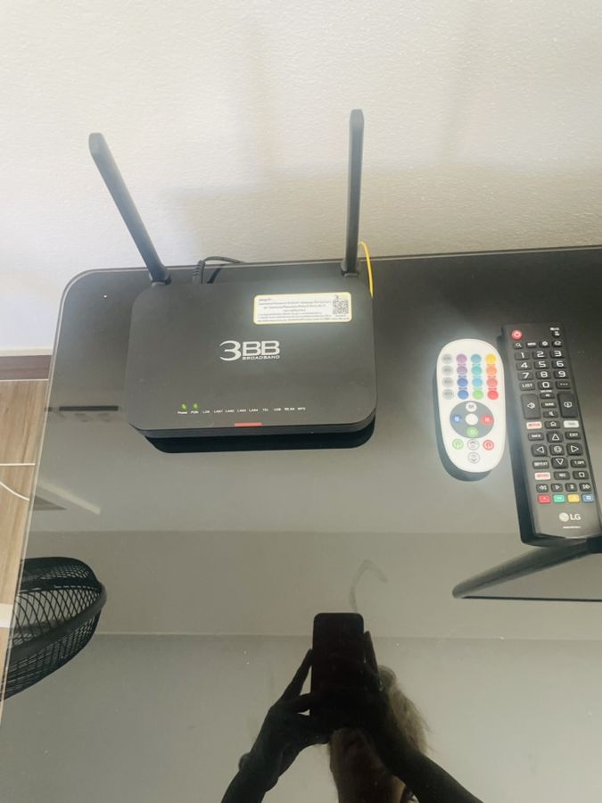 Wi-Fi router and TV and AC remotes on the console table